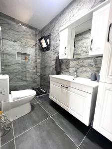 La salle de bains est pourvue d'un lavabo blanc et de toilettes. dans l'établissement Luxury and comfortable villa with a view, à Milas