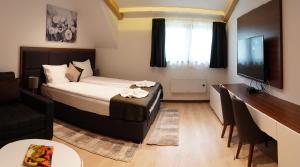 a bedroom with a bed and a tv and a table at Velvet Studio Zoned Kopaonik in Kopaonik +49 photos