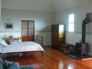 um quarto com uma cama e um fogão a lenha em St Peter's Fairview em Branxton