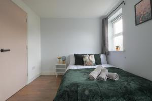 ein Schlafzimmer mit einem Bett mit zwei Hausschuhen darauf in der Unterkunft Stayright Stylish Cardiff Bay 2 Bed Apartment- Private Parking & 10 mins to Bay & City in Cardiff