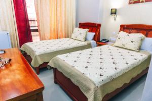 a small bedroom with two beds and a table at Hôtel Atenas in Tetouan