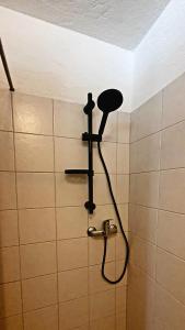 een douche in een badkamer met een douchekop bij Relais de Noël in Nus