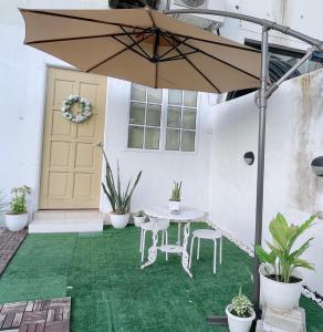een patio met een tafel en een parasol bij Helena’s Studio Suite Gerik in Gerik