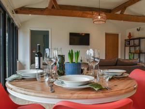 a table with plates and wine glasses on it at Post Box Lodge in Dickleburgh