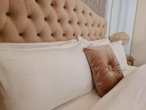 Amazing Villa in Muscat في سيب: سرير مع اللوح الأمامي مبطن بني ومخدة