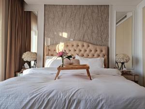 Amazing Villa in Muscat في سيب: غرفة نوم مع سرير أبيض مع طاولة عليها