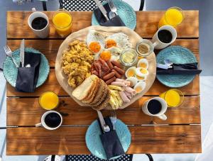 un tavolo in legno con un piatto per la colazione composto da prodotti per la colazione di Fertimo Suites by Karpimo a Éxo Goniá