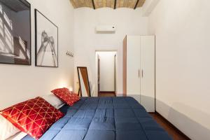 Un dormitorio con una gran cama azul con almohadas rojas. en Majestic Trastevere, en Roma