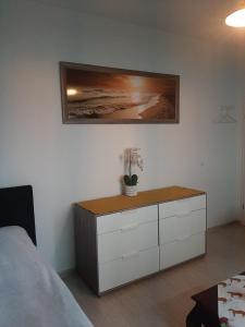 a bedroom with a bed and a dresser with a plant on it at Am Bahnhof in Werneuchen