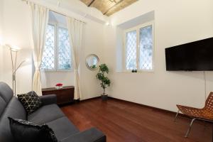 Una sala de estar con un sofá y un televisor de pantalla plana. en Majestic Trastevere, en Roma