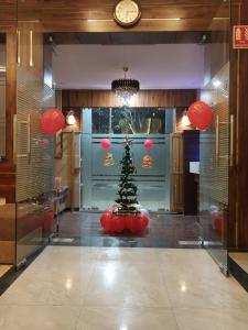 un albero di Natale in una stanza con un orologio di Taj Nice Point Manage by Taj Sunrise Group ad Agra