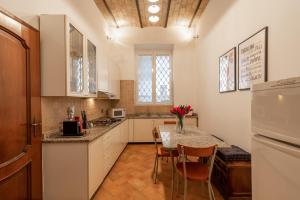 Una cocina con una mesa con sillas y un refrigerador. en Majestic Trastevere, en Roma