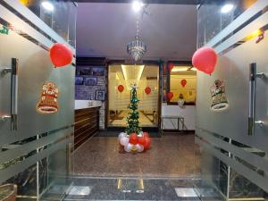 a room with a christmas tree and red balloons at Taj Nice Point Manage by Taj Sunrise Group in Agra