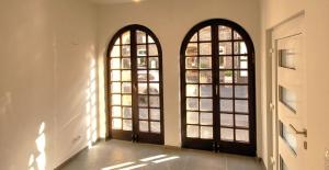 zwei Bogenfenster in einem Zimmer mit Tür in der Unterkunft ZUM GUTEN HIRTEN in Traben-Trarbach + 4 Fotos