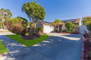 a house with a driveway and a tree in a yard at 5 Bedroom Charmer with Pool in Reseda