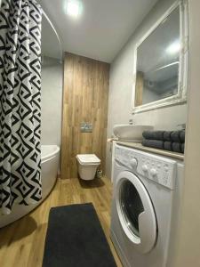 a bathroom with a washing machine and a toilet at Stylish apartment in the historic center in Chernihiv