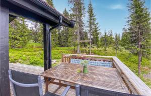 una terraza de madera con mesa y sillas. en Gorgeous Home In Lillehammer With Wifi en Lillehammer