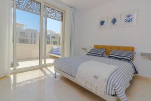 una camera bianca con un letto e una grande finestra di Mangroovy Seaview 1BR Beach and Pool Free access a Hurghada
