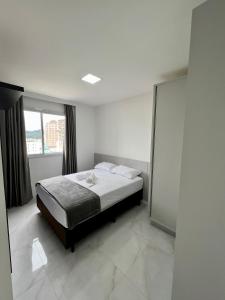 1 dormitorio con cama y ventana grande en Apartamento próximo à praia, en Itapema