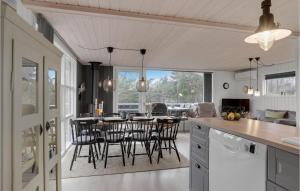 a kitchen and dining room with a table and chairs at 4 Bedroom Nice Home In Blokhus in Blokhus