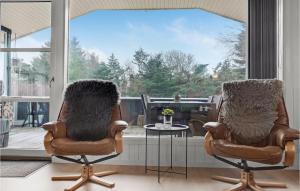 two chairs and a table in a room with a window at 4 Bedroom Nice Home In Blokhus in Blokhus