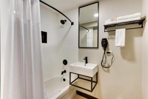 a white bathroom with a sink and a shower at The Shamrock in Cicero