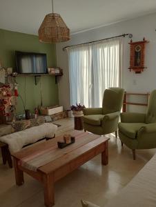 sala de estar con mesa de centro y 2 sillas en Calida y acogedora casa ubicada en barrio residencial en Tandil