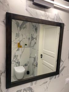 een spiegel aan de muur met een toilet in de badkamer bij Lux Studio HOTEL in Keyla