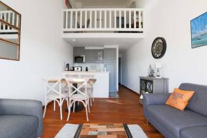 a living room with a couch and a table and a kitchen at Sur l'îlot de St Martin au centre du port vue exceptionnelle ! in Saint-Martin-de-Ré