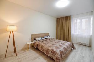 a bedroom with a bed and a lamp and a window at Апартаменти на Жасминовій в парковій зоні in Lviv
