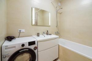 a washing machine in a bathroom with a sink at Апартаменти на Жасминовій в парковій зоні in Lviv