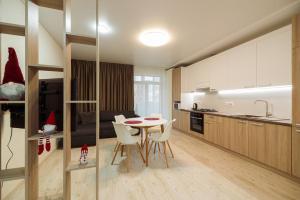 a kitchen and living room with a table and chairs at Апартаменти на Жасминовій в парковій зоні in Lviv