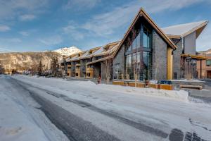 a building on a snow covered street in front at Peaks Hotel and Suites in Banff