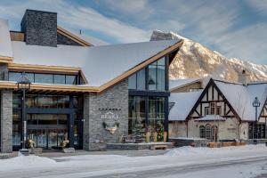 a building with a snow covered mountain in the background at Peaks Hotel and Suites in Banff