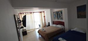 a small bedroom with two beds and a window at Huanchaco Paradise Hotel in Huanchaco