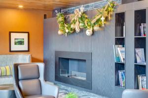 a living room with a fireplace and a chair at Peaks Hotel and Suites in Banff