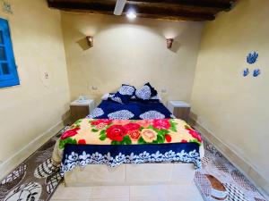 una camera da letto con un letto fiorito di خزفستا Khazfista a ‘Izbat an Nāmūs