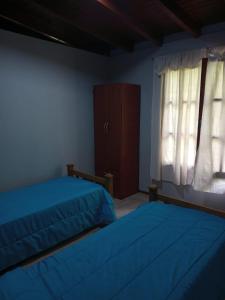 盧漢德庫約的住宿－Sol de montaña，一间卧室设有两张床、一个梳妆台和窗户。