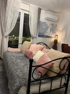 a bedroom with a bed with pillows and a window at Apartmani Sollei in Petrcane