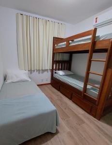 a bedroom with two bunk beds and a ladder at Casa em Barra Grande com piscina in Marau
