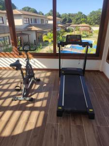 a gym with two exercise bikes and a large window at Casa em Barra Grande com piscina in Marau