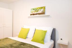 a bedroom with a bed with two yellow pillows at Premium City Apartment with balcony! Free Garage Parking included! in Vienna