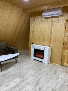a living room with a fireplace in a wooden wall at Green Villa Resort White in Dilijan
