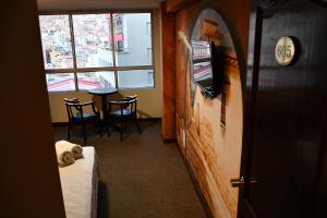 a room with a bed and a table and a window at Terraza Hotel in La Paz