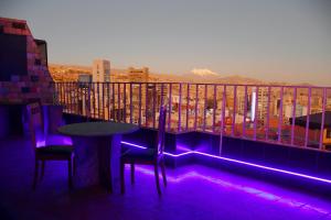 a table and chairs on a balcony with purple lights at Terraza Hotel in La Paz