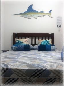 a bedroom with a bed with a shark on the wall at Suíte Trilha do Sol 2 in Arraial do Cabo