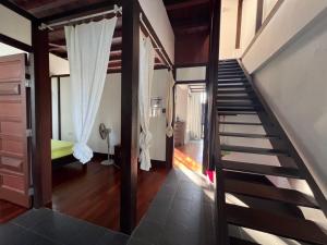a staircase in a room with a bedroom and a bed at Gaze: Entire Modern Tropical Seaview Villa in Pantai Cenang