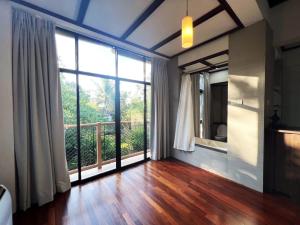 a room with a large window and a wooden floor at Gaze: Entire Modern Tropical Seaview Villa in Pantai Cenang