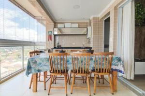 a kitchen with a table and chairs in a room at APTO NOVO PÉ NA AREIA - Praia do Sonho, Itanhaém in Itanhaém