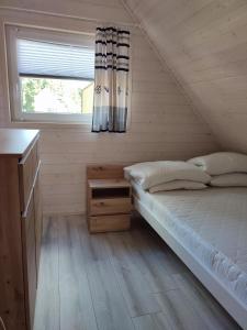 ein kleines Schlafzimmer mit einem Bett und einem Fenster in der Unterkunft Zielonka Relaks in Rusinowo
